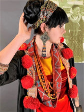 Load image into Gallery viewer, Closer view of large pompoms on jacket. Model also wearing Naga bead, amber, and strap necklaces also available in our shop.
