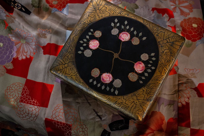 Lacquer box showing floral motif and gold leaf decorated with geometric design and butterflies.