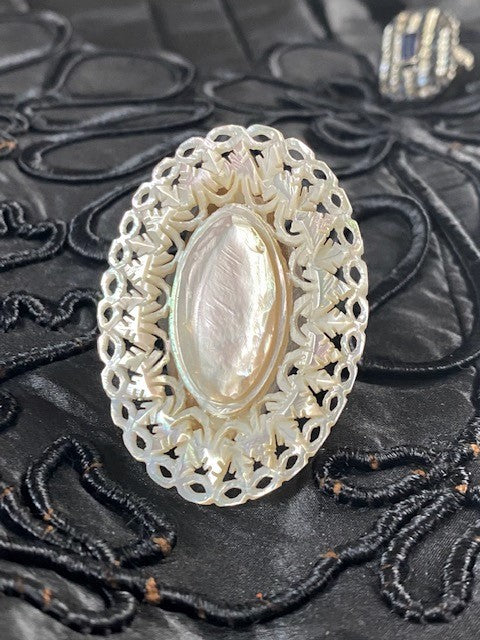 Closeup of intricately carved mother-of-pearl ring.