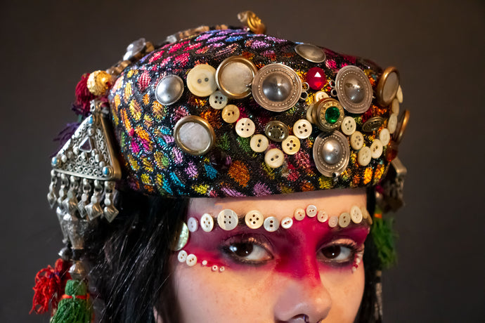 Upcycled vintage pillbox hat maximalized with heirloom mother-of-pearl  buttons, silver Afghan clothing ornaments, antique Pashtun silver triangular ornaments and Afghani tent band tassels with silver.