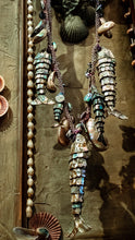 Load image into Gallery viewer, Detail photo of articulated fish bottle openers covered in iridescent  abalone.
